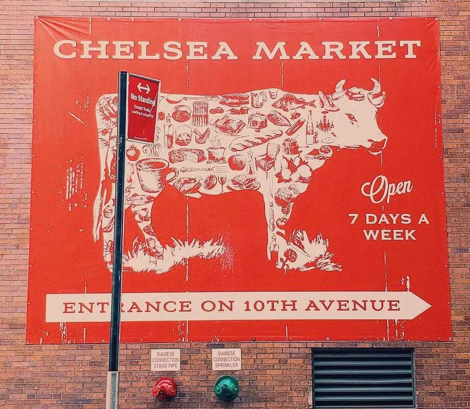 A red with a cow advertising for Chelsea Market.