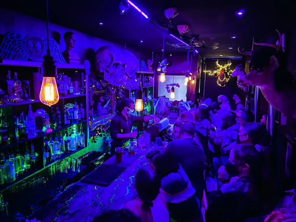 Spooky interior of Beetle House with a black light at one of the best Themed bars in NYC.