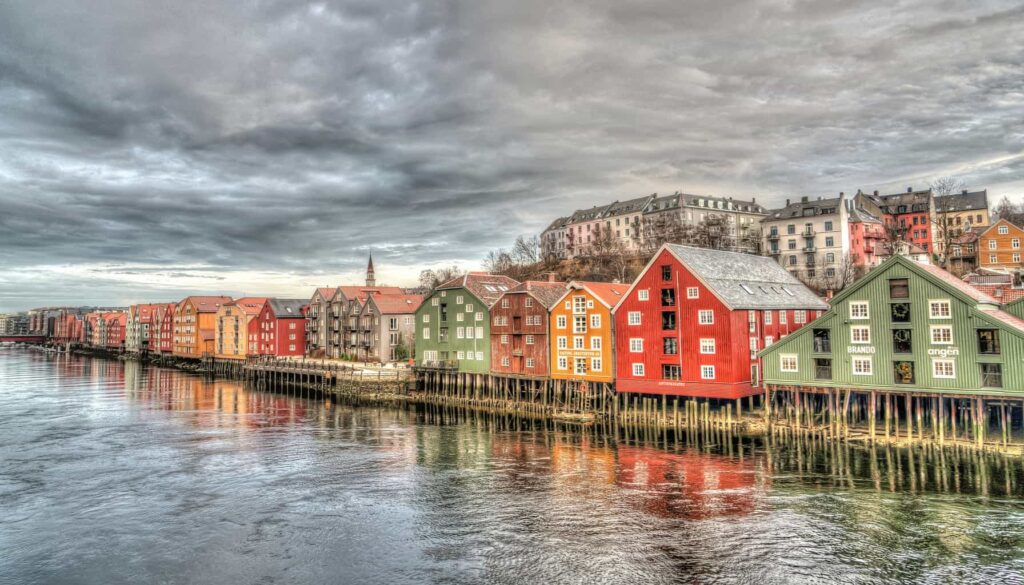 A view of the colorful houses that line the waters of Trondheim on a cloudy day in Norway. This is one of the prettiest places in Norway. 