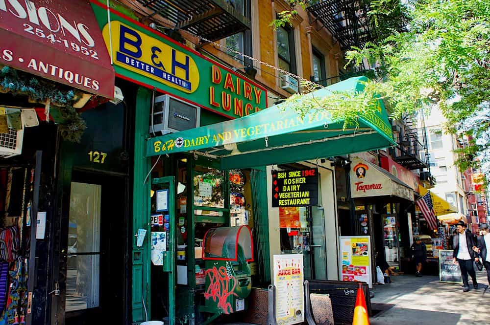 The colorful exterior of B&H dairy with its numerous signs that is one of the best brunch spots in NYC