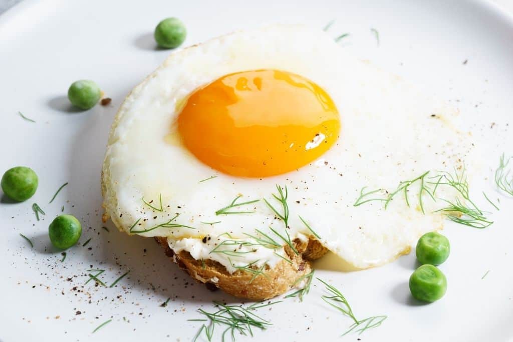 Over easy egg on toast and green peas is one of the popular things to eat if you are headed out to Momofuku Ko and are looking for some of the best brunch in NYC.