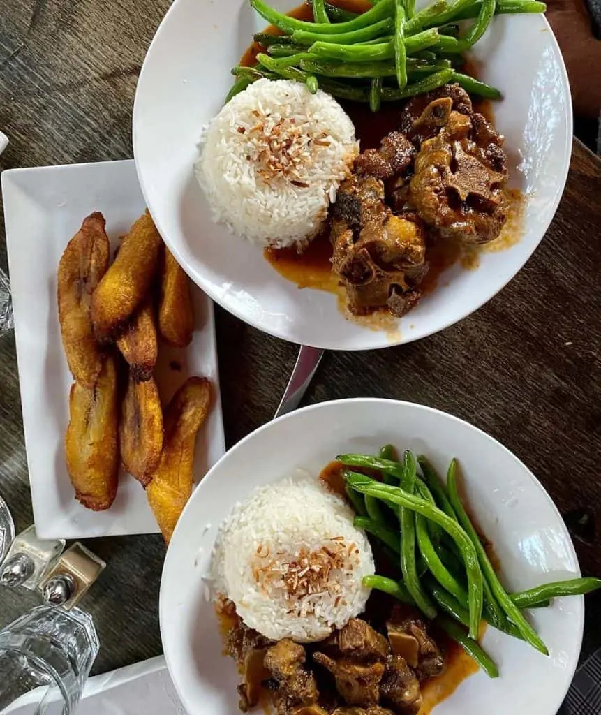 The Edge Plate of Oxtail with rice and green beans served with fried banana is one of the iconic unusual dishes to try for brunch in NYC