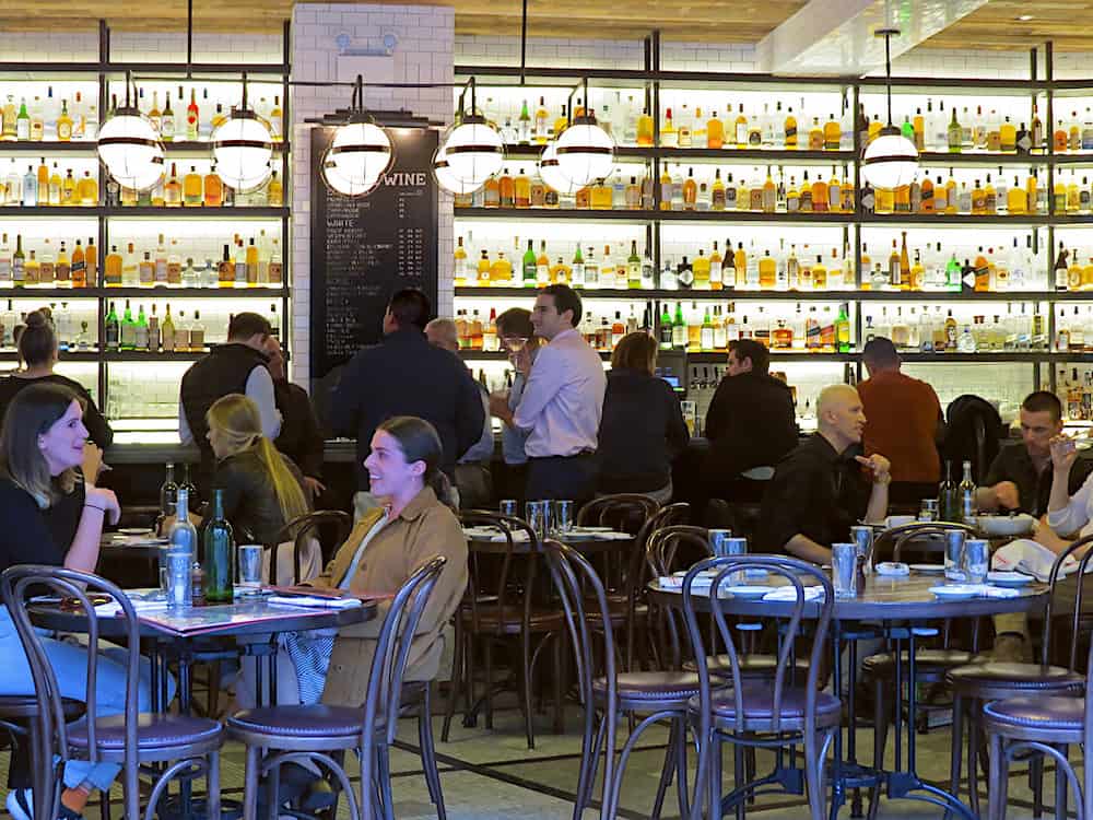 The Interior of the Smith in NYC with its well stocked bar and crowded tables is one of the best places to catch brunch in NYC