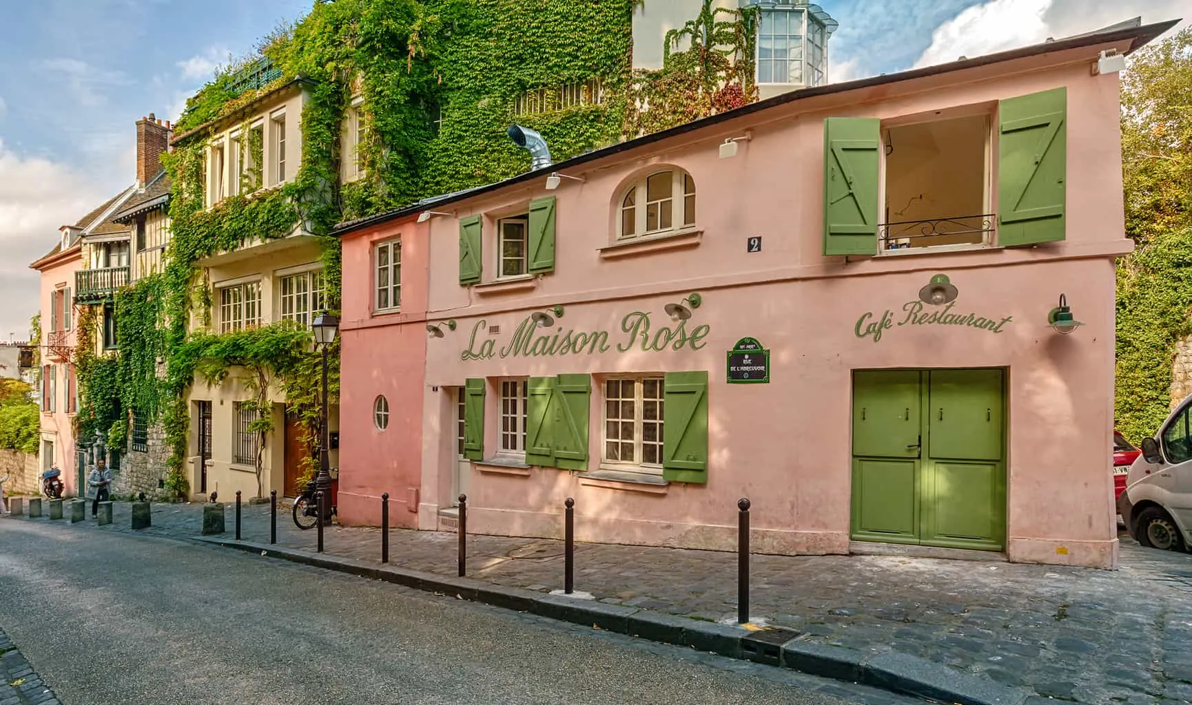 The beautiful, pale pink and lime green exterior of La Maison Rose in Montmartre, Paris.