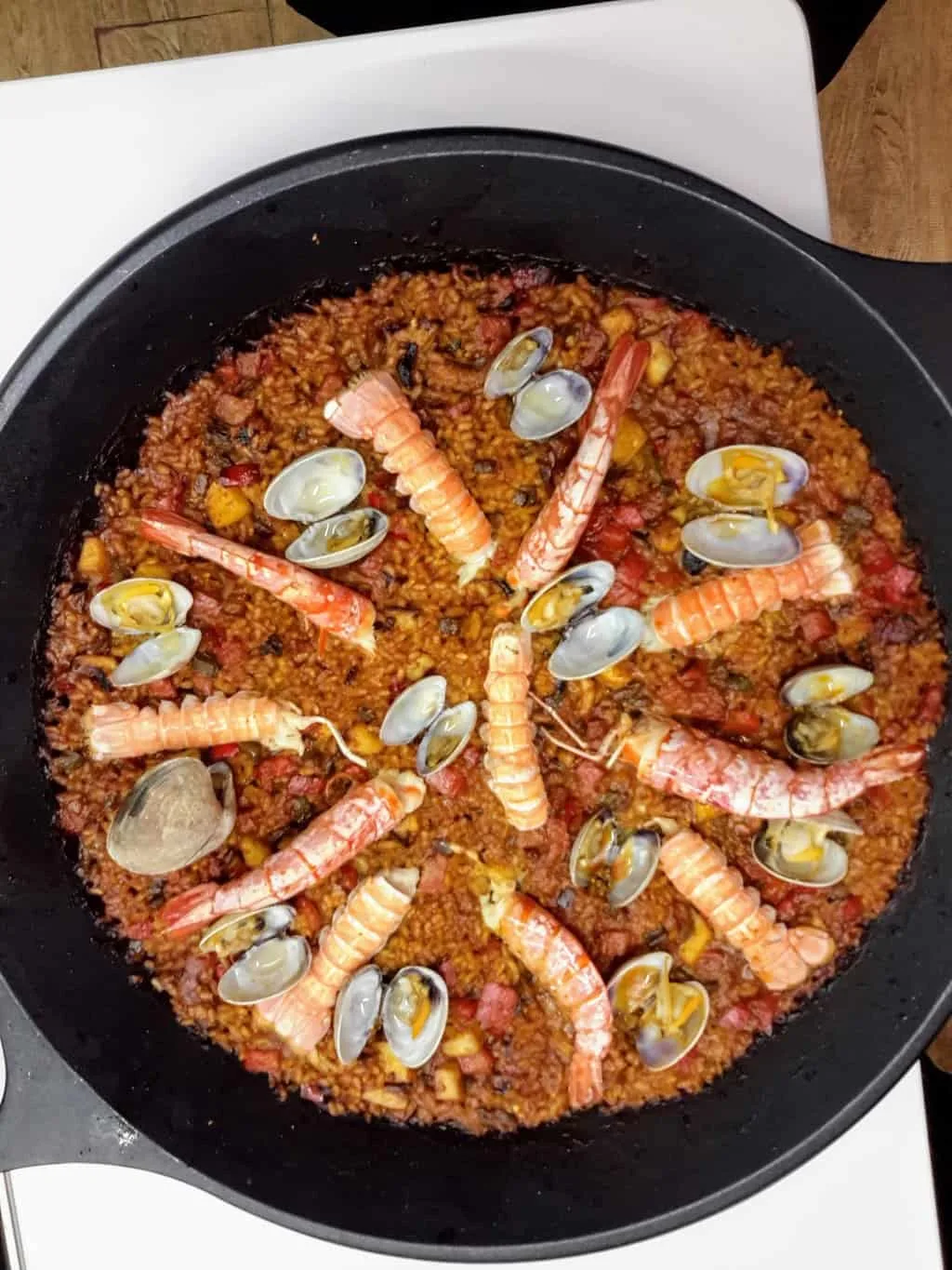 A castiron skillet full of the authentic, seafood paella that you'll make during your Catalan cooking class with BCN Kitchen. 