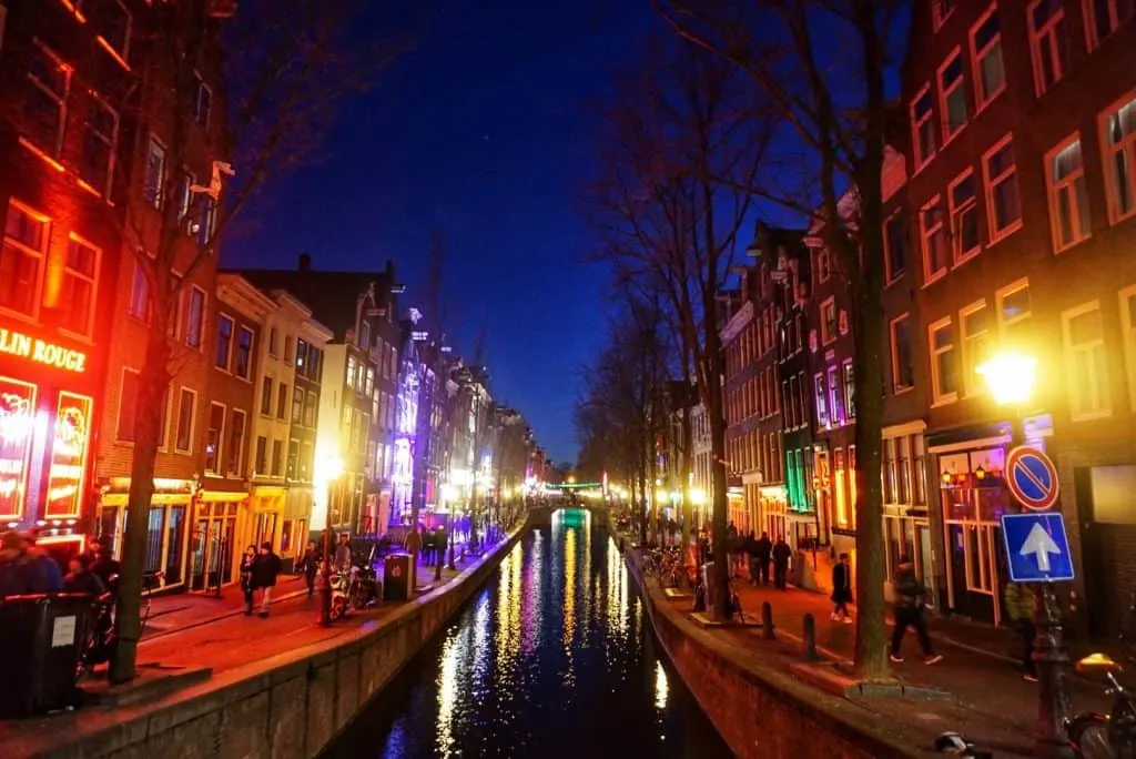 View of the bright lights and canals of the Red Light District in Amsterdam in the evening. 
