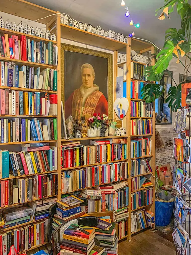 The bright, vibrant, and book-filled interior of the Happy Bookleman in Amsterdam. 