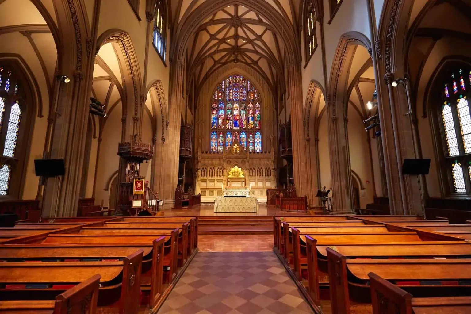 Beautiful stained glass windows and quaint wooden pews make up the interior of New York City's famous, Trinity Church, 