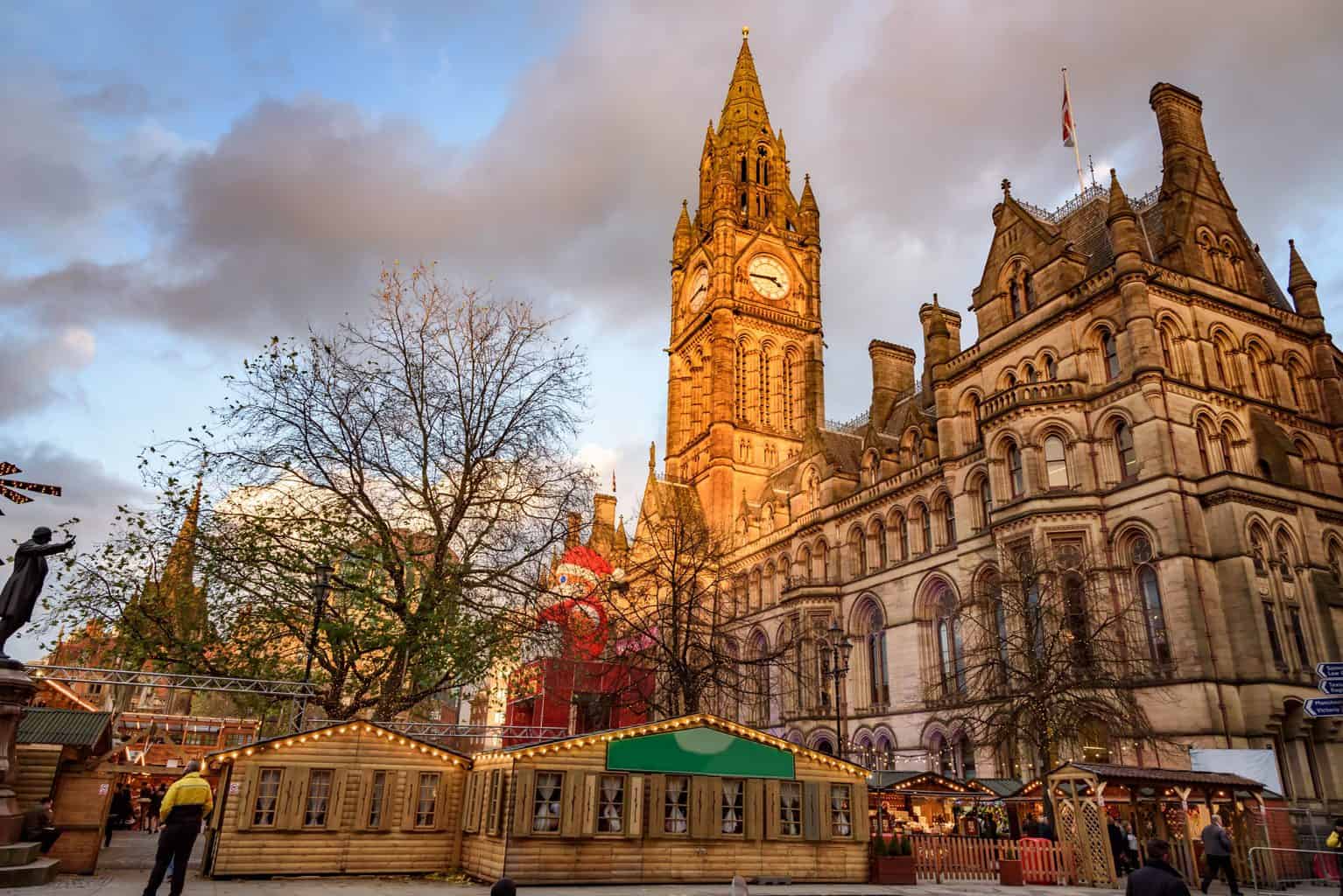 Manchester town hall and the vibrant Christmas market at Albert Square in Manchester, England.