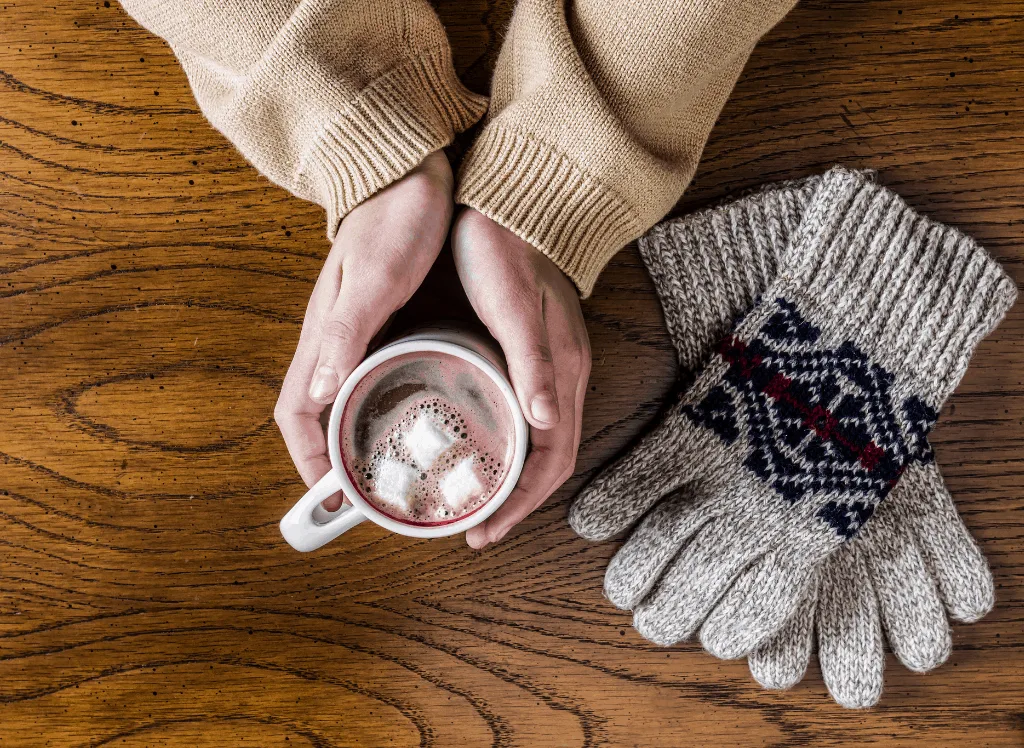 Holding a cup of hot cocoa during the winter. 