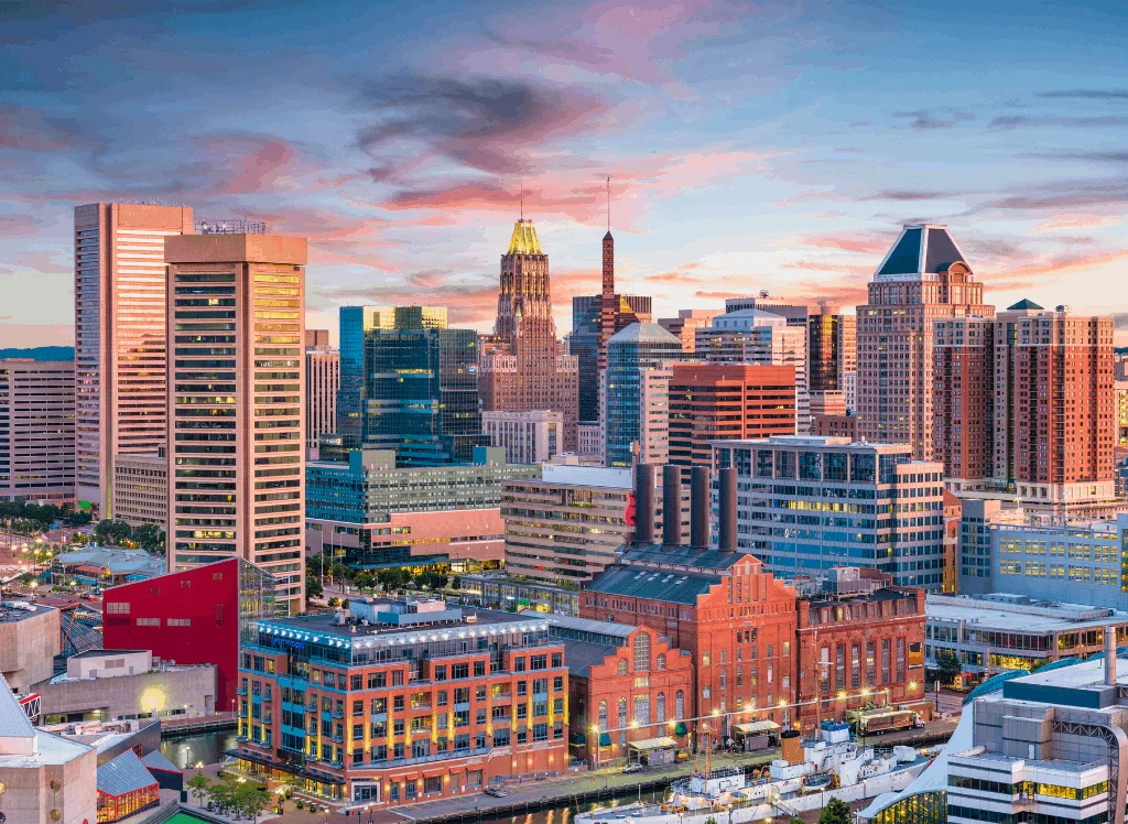 View of the Baltimore skyline at dusk during your New York to Florida road trip. 