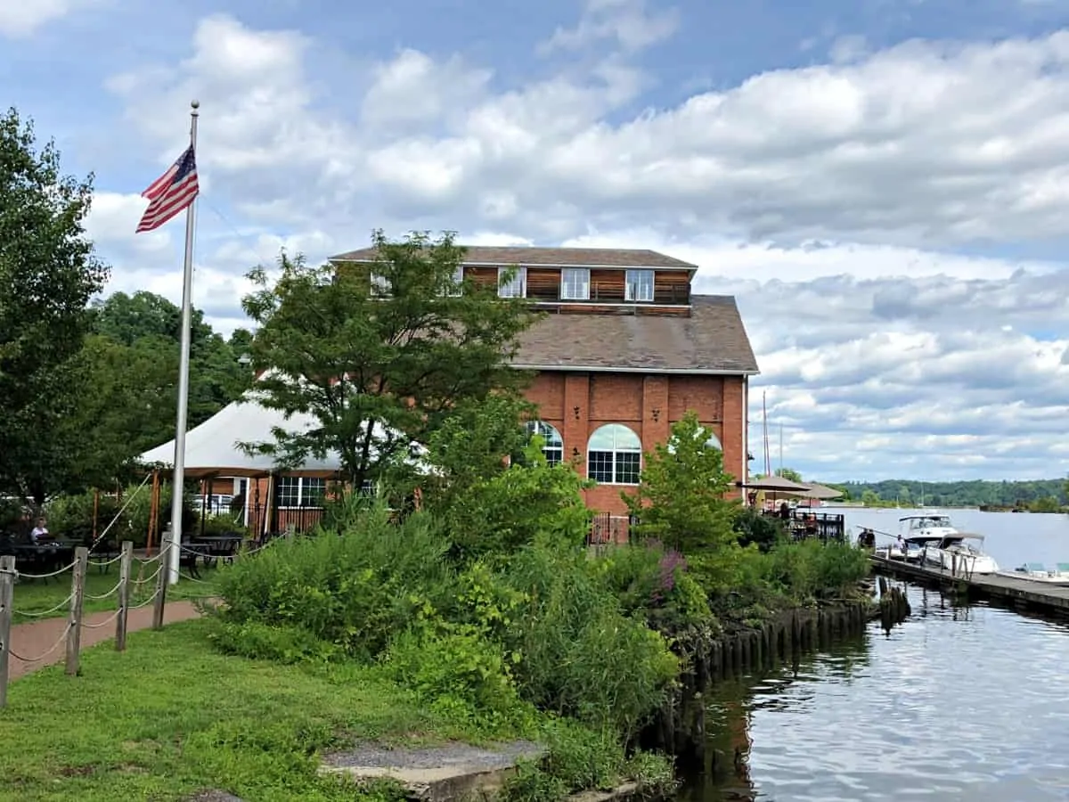 Kingston's beautiful waterfront area with its green banks and a brick building at one of the best  romantic getaways in Upstate New York