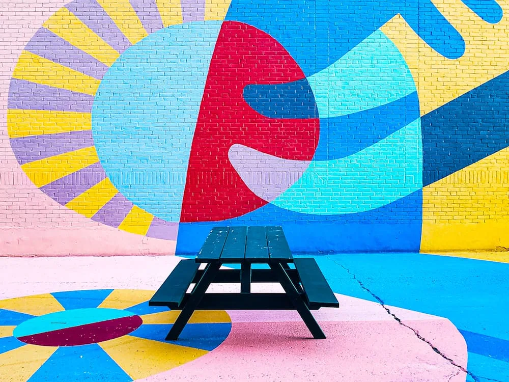 Picnic Table and Wall Art outside of Fog Bar