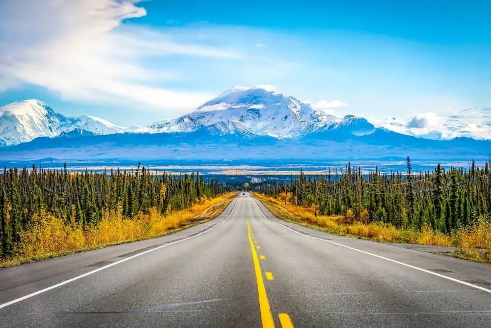 Road that takes you to the mountains in Canada during your summer road trip. 