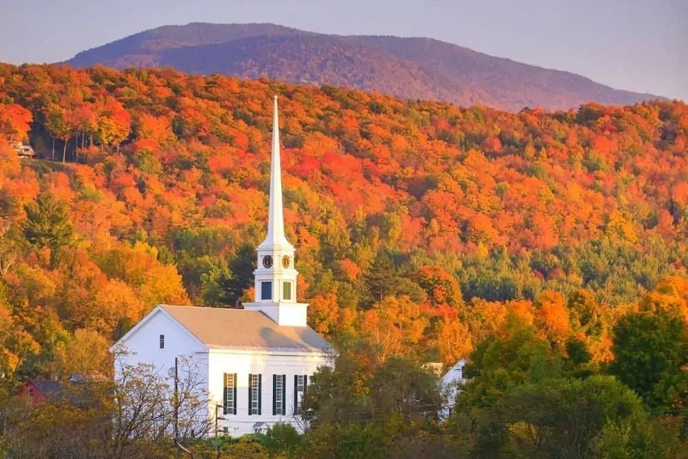 A white church surrounded by fall foliage in rural Vermont. 