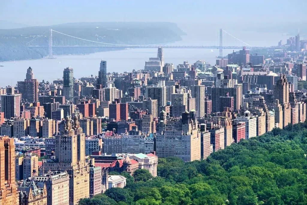 Aerial view of Central Park and the buildings on the Upper West Side, with the George Washington Bridge in the background. 