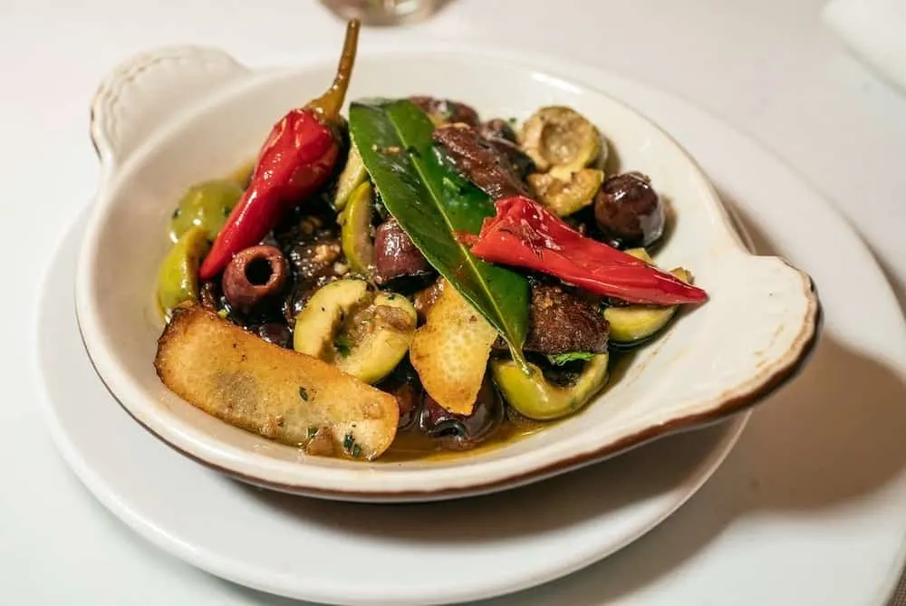 Sautéed vegetables in a plain white dish from Nice Matin, one of the best thing to do in the Upper West Side NYC. 