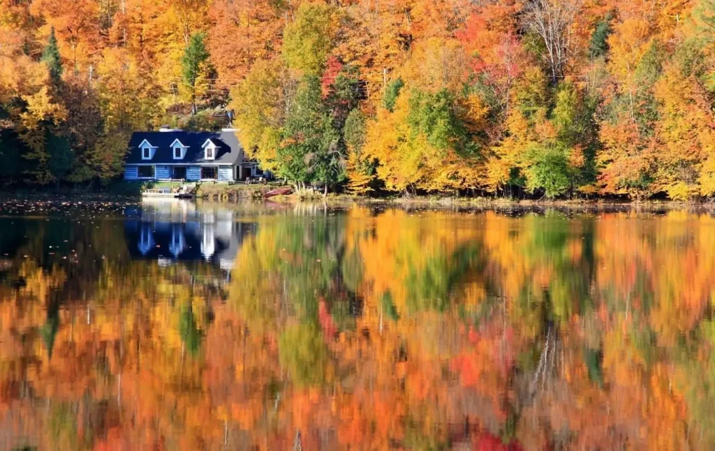 House Sitting on a Lake surrounded by fall foliage in Quebec, Canada.