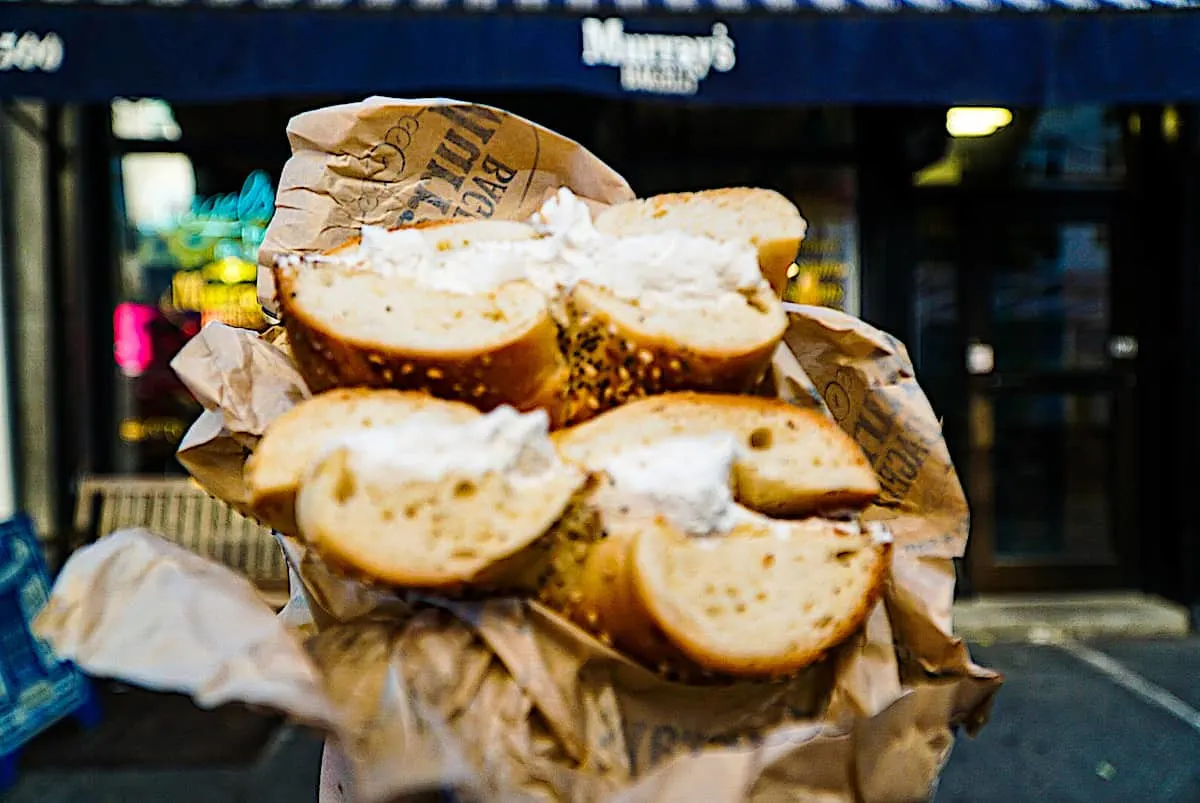 Bagels and cream cheese cut and wrapped in a brown paper at one of the best places to eat in NYC