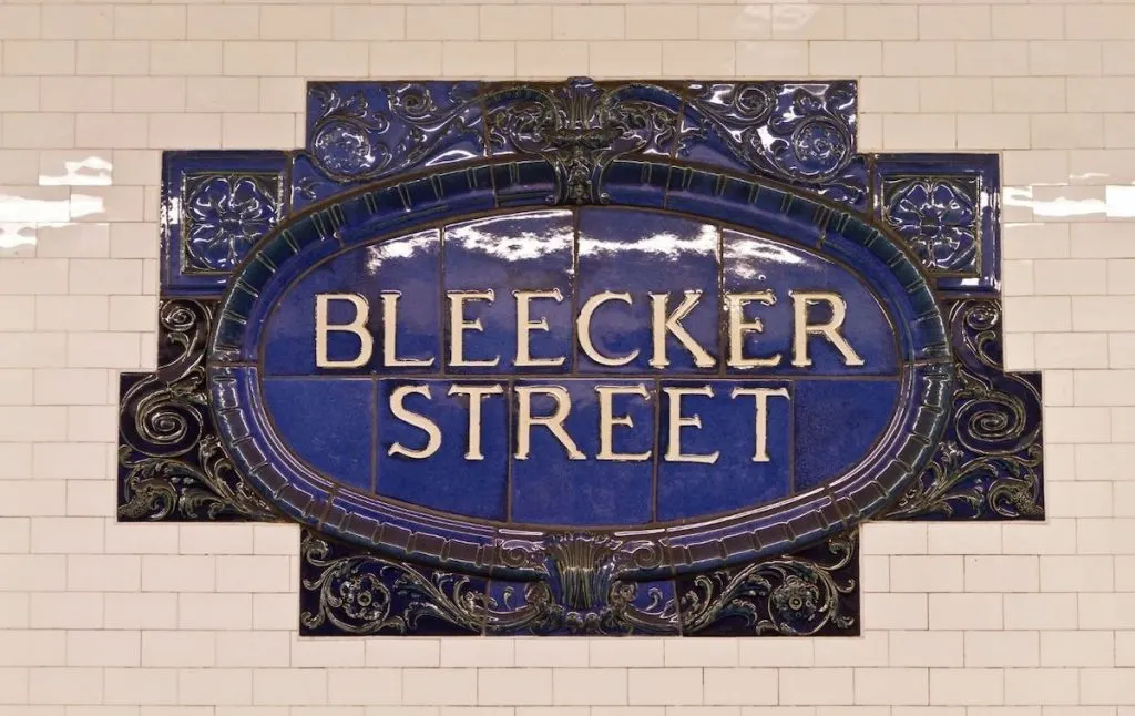 Blue subway staton sign for Bleecker Street. 