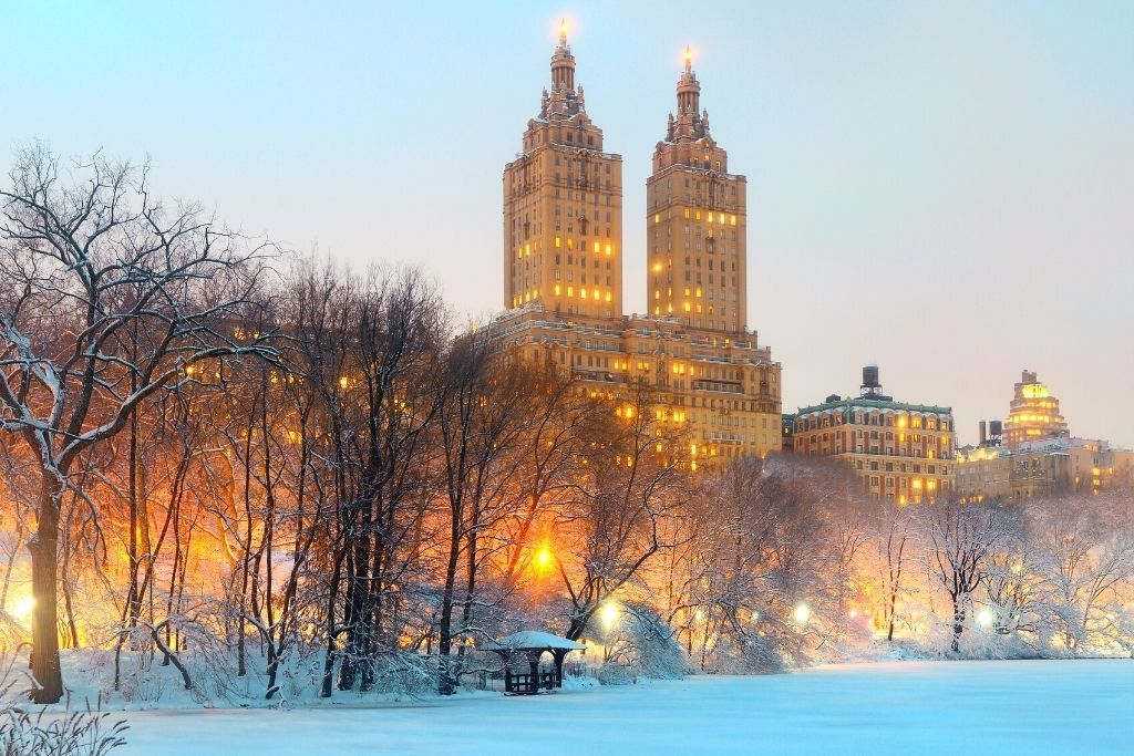 Central Park covered in snow in the evening and is home to some of the best New York Christmas lights. 