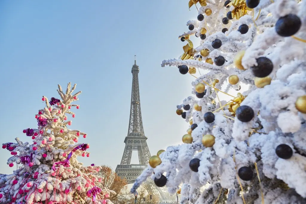 Pairs in winter with Christmas trees surrounding the Eiffel Tower. 
