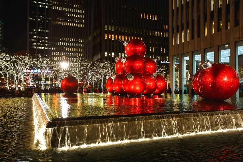 Giant red Christmas ornaments in the fountain just outside Radio City Music Hall, home to the best NYC Christmas lights. 