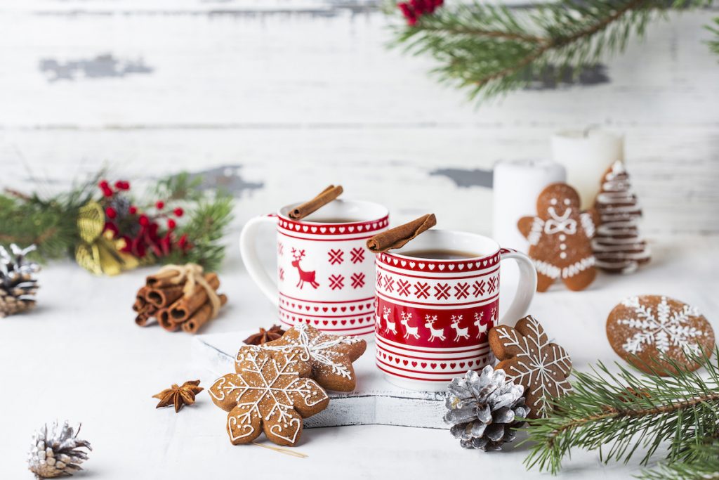 Cute holiday mugs with cinnamon and gingerbread cookies. 