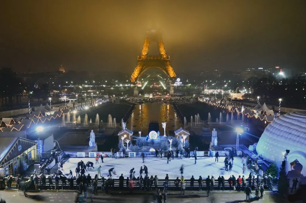 People ice skating in the evening on the rink at the Eiffel Tower this winter in Paris. 