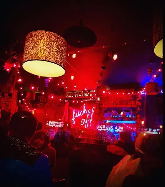 Interior of Booby Tra with its red and blue lights and people partying in one of the most unique bars in NYC. 