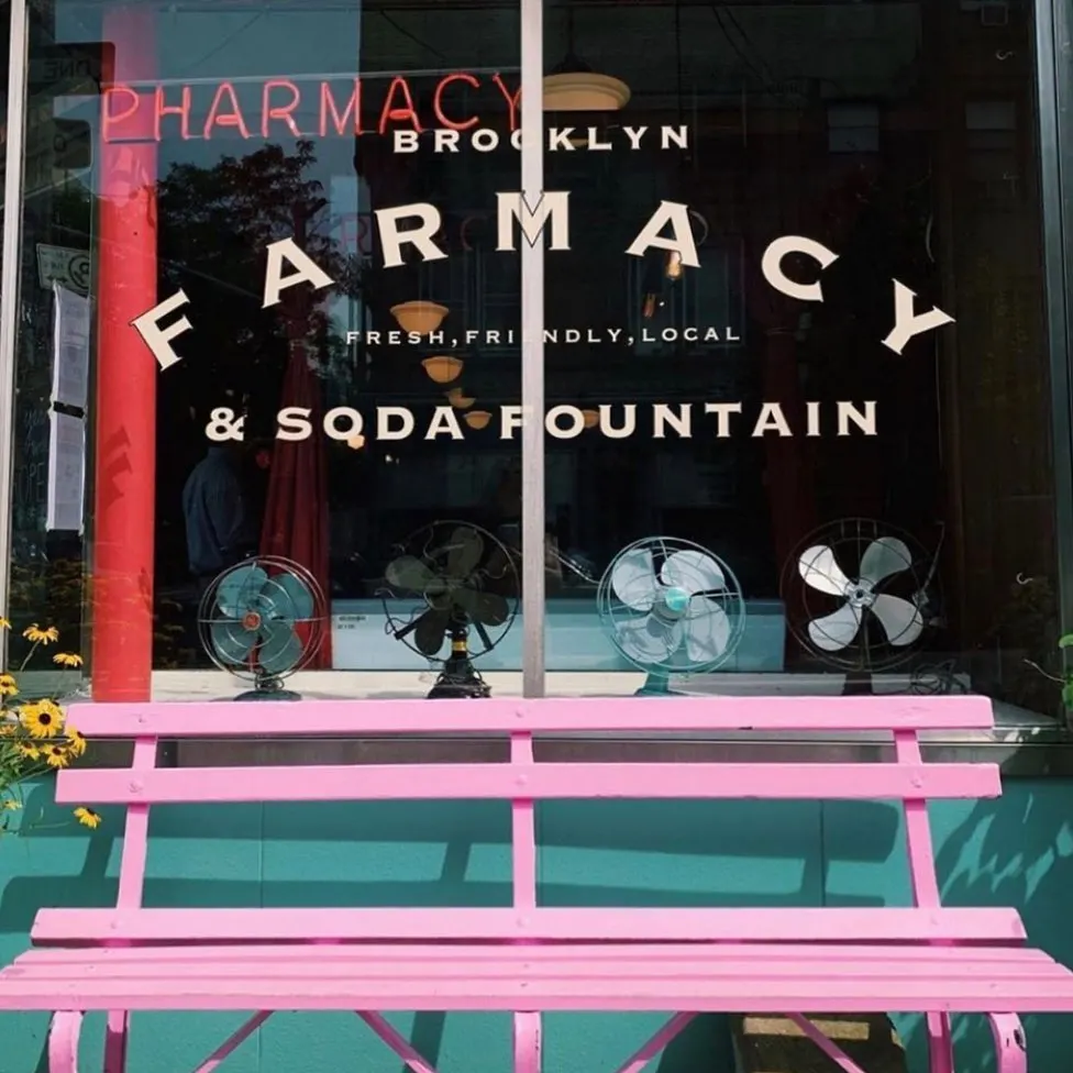 Turquoise and pink exterior of the Brooklyn Farmacy and Soda Fountain, one of the best themed restaurants in NYC. 