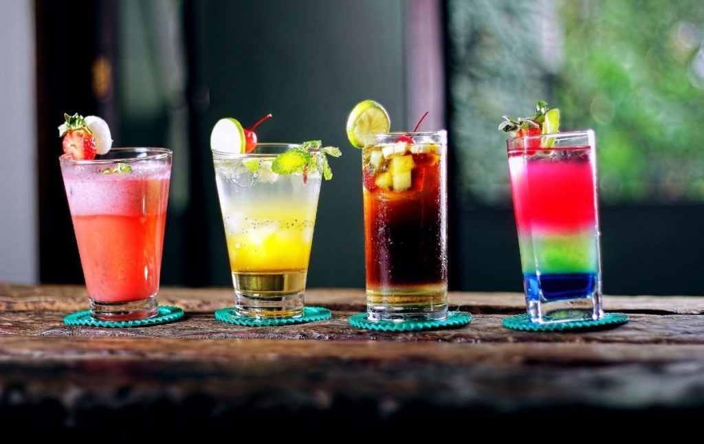 Four fresh cocktails on a wooden bar. 