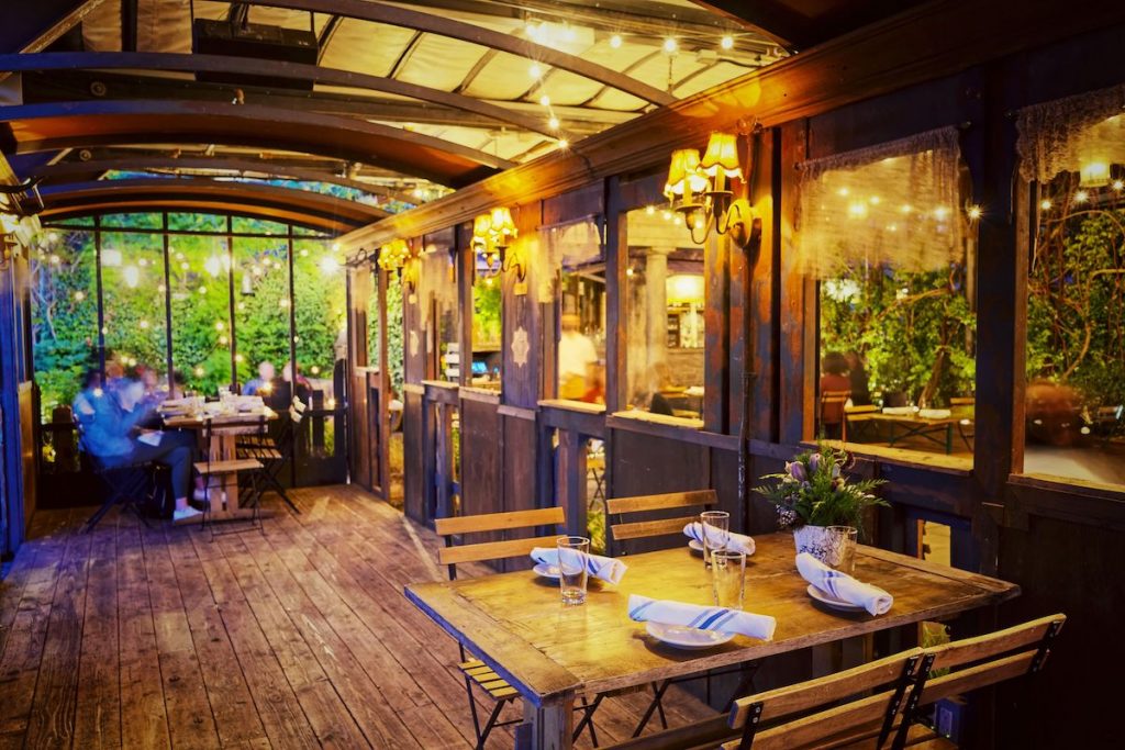 Train car inspired dining room of Gallow Green, one of the top rooftop restaurants NYC has to offer. 