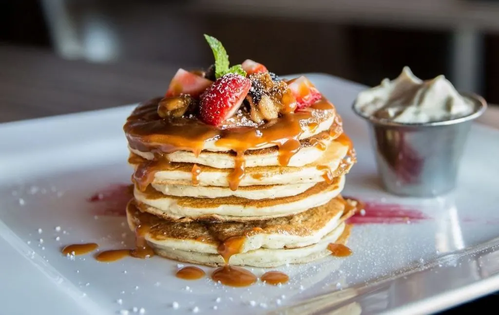 Pancakes topped with caramel and berries at a bottomless brunch nyc rooftop.