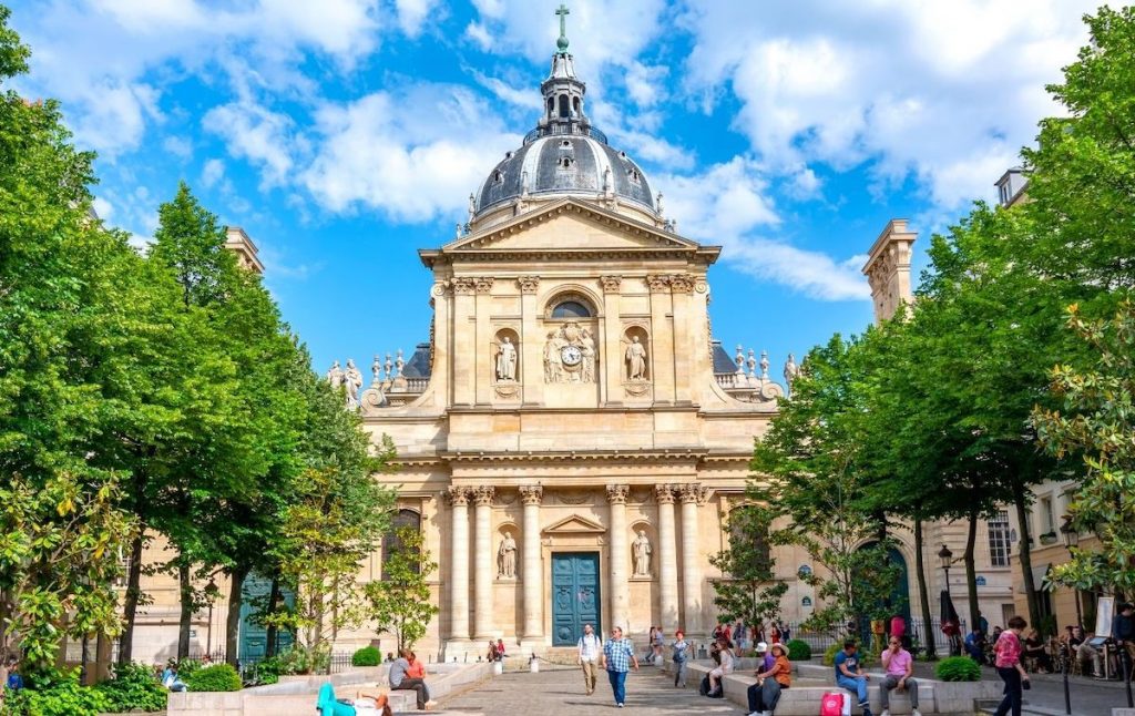 Sorbonne Chapel in the Latin Quarter on a sunny day and surrounded by green trees.