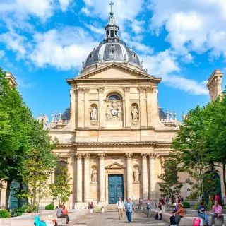 Sorbonne Chapel in the Latin Quarter on a sunny day and surrounded by green trees.