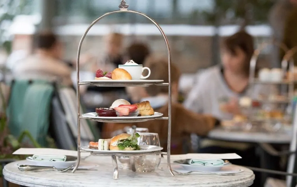 Afternoon tea on a three-tiered plate at a table in a cafe that serves the best afternoon tea in Paris. 