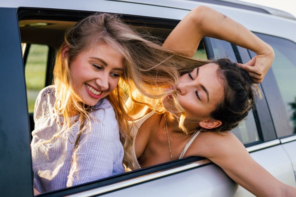 Two girls hanging out in a car as they learn how to make friends while traveling solo. 