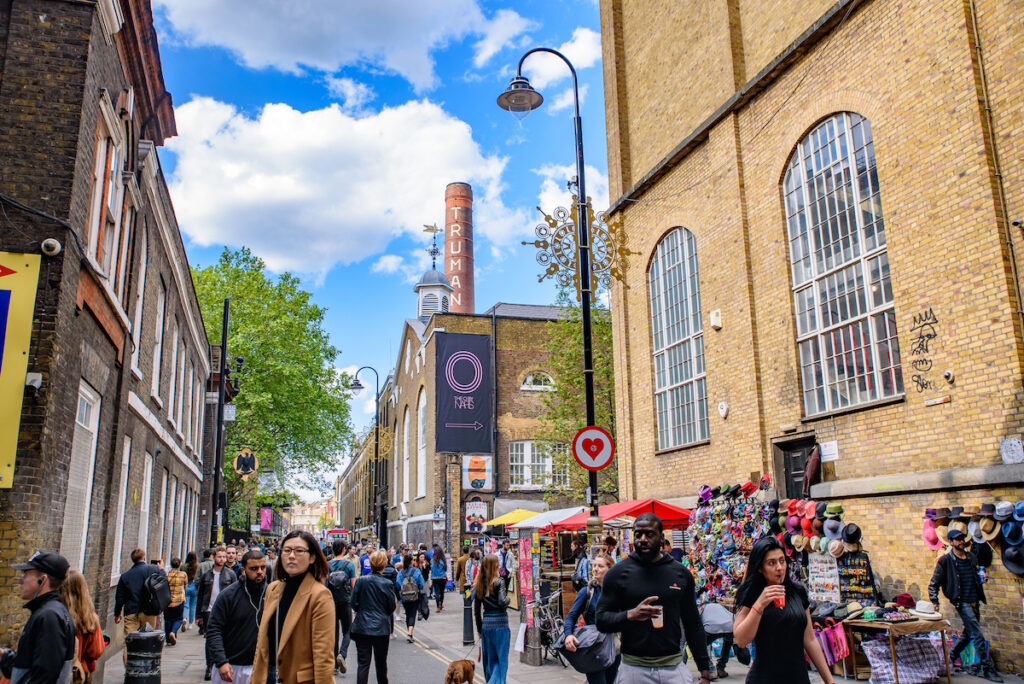 Shoppers enjoying Brick Lane Market and walking down one os the cutest streets in London.