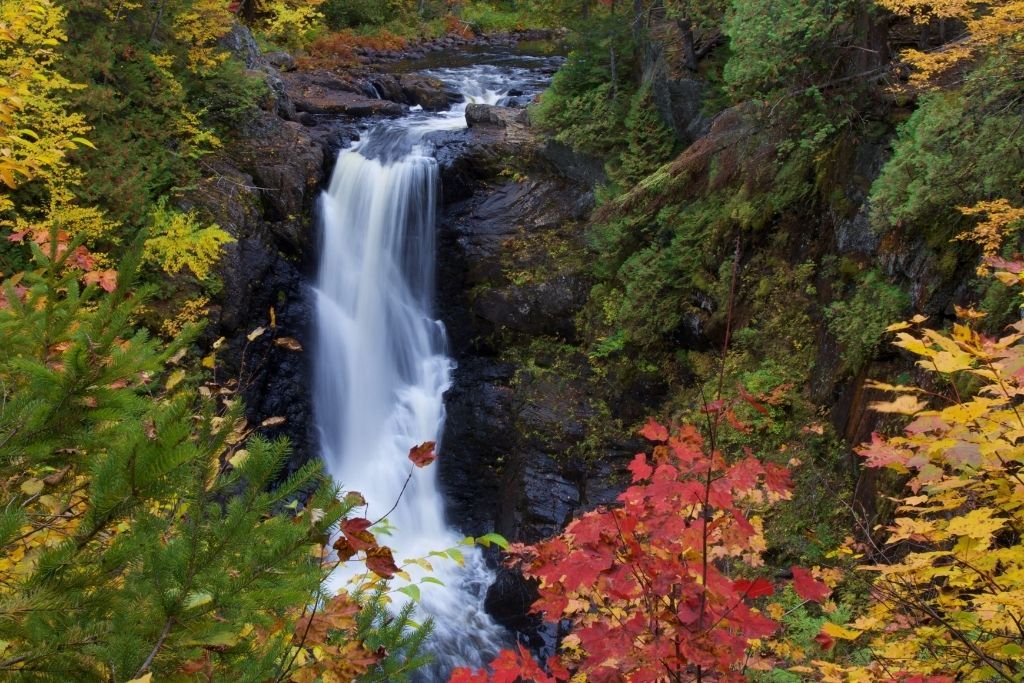 Moxie Falls surrounded by fall foliage on one of the best hikes in Maine. 