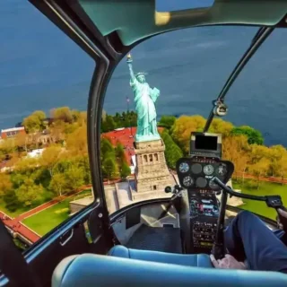 A helicopter pilot looking out at the Statue of Liberty. A helicopter tour is as one of the top things to do in NYC on your birthday.
