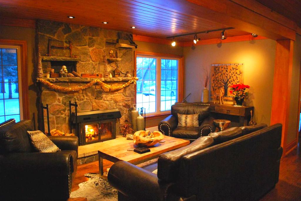 Cozy log cabin-inspired living room with a roaring fire inside one of the best Ontario resorts for couples. 
