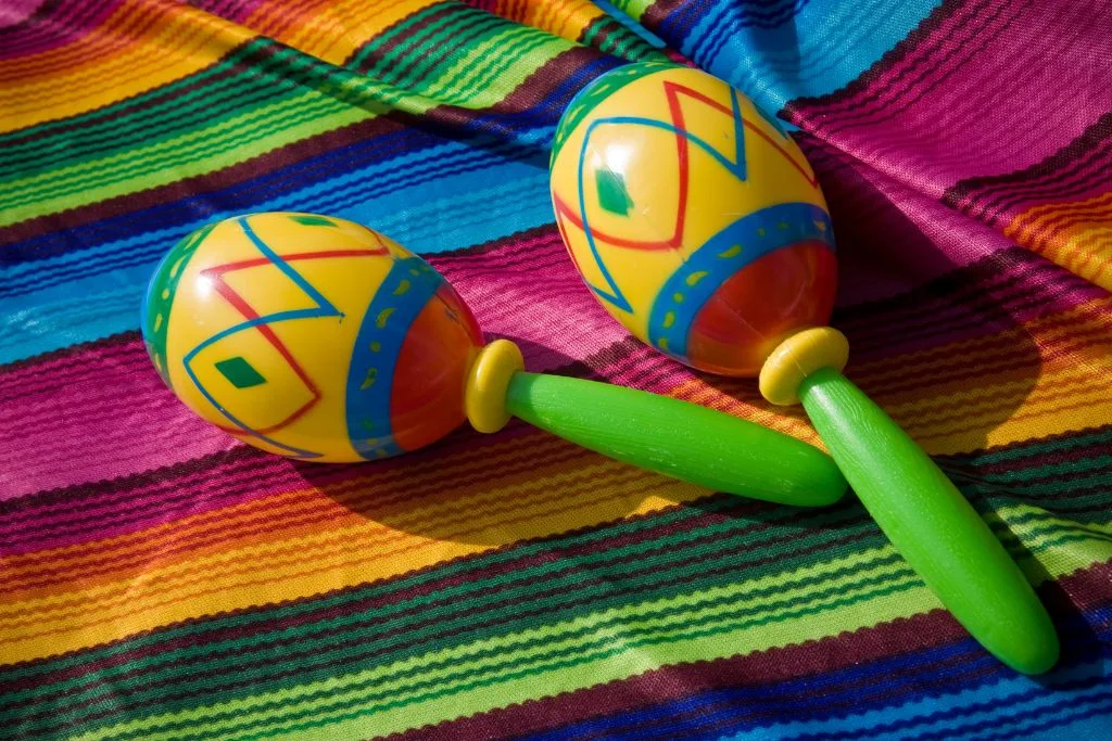 Colorful maracas on a colorful blanket. 
