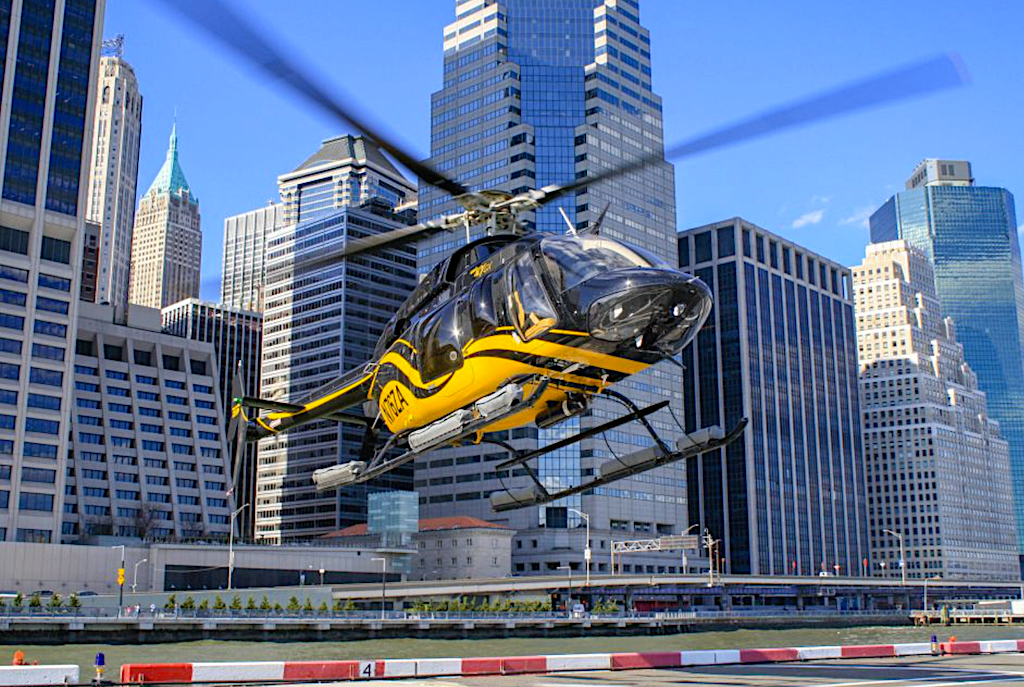Yellow helicopter departing from a flight pad in lower Manhattan during one of the best New York City  helicopter outs. 