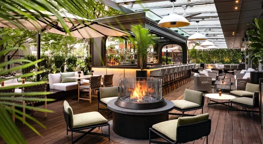 Stunning dining room with lots of greenery and an outdoor fire pit at the Ritz Carlton, one of the best boutique hotels downtown Toronto has to offer. 