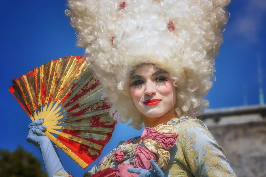 Woman wearing a Baroque-style costume with matching hair. 