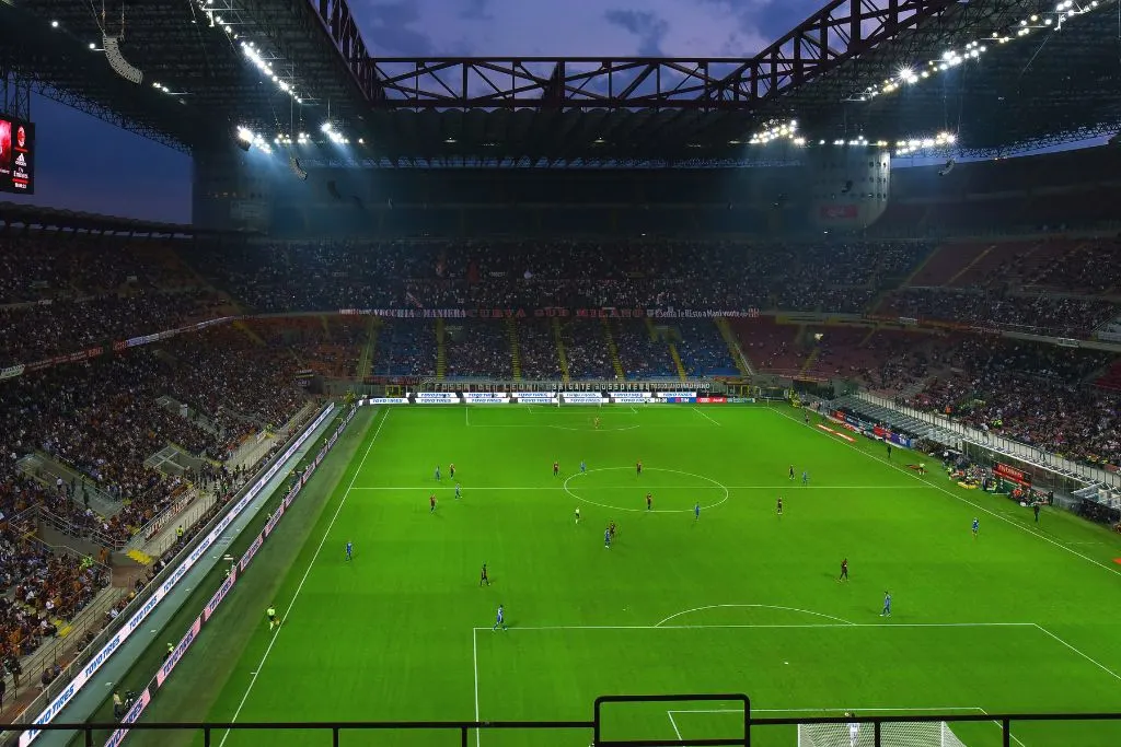 Soccer players playing on the field of San Siro Stadium in Milan. 