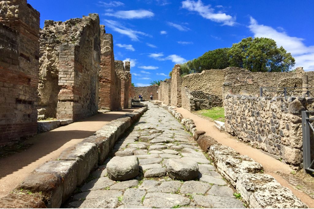 Tourists exploring the ruins of Pompeii by foot. 