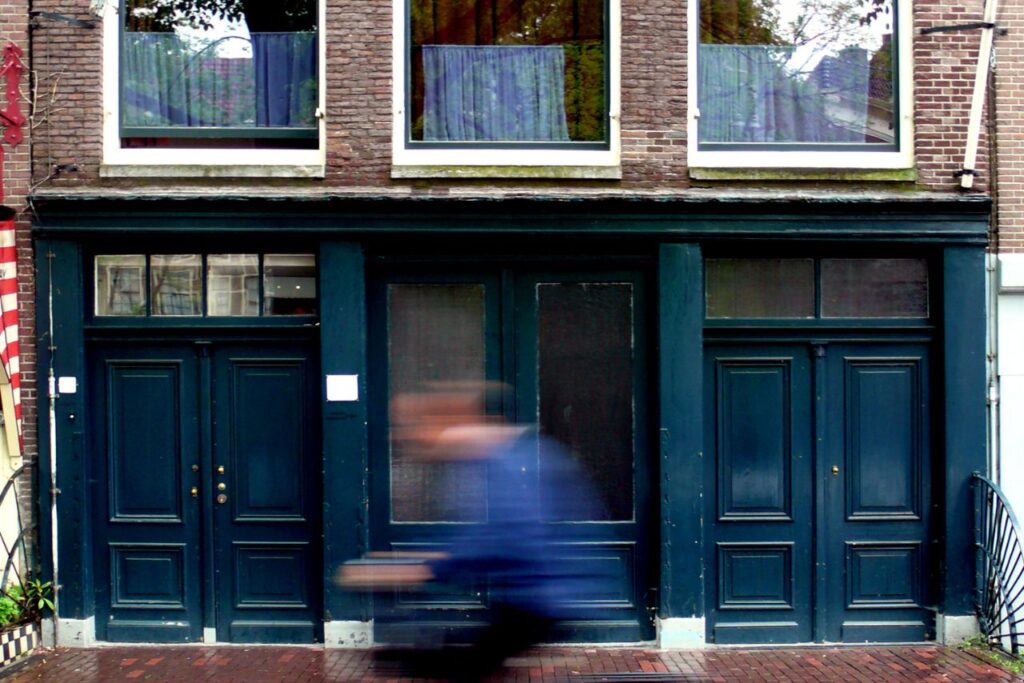 View of a man riding a bike in front of the Anne Frank House during 24 hours in Amsterdam. 
