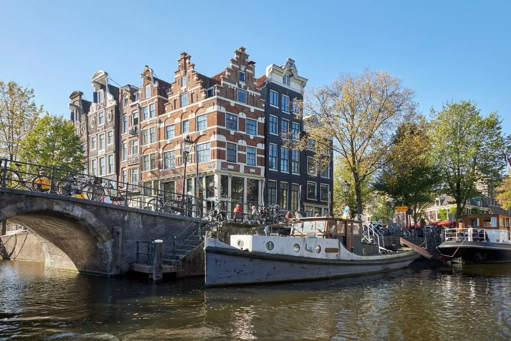 View of the row houses along Brouwersgracht canal and the housbaots in the water during your one day in Amstredam itinerary.